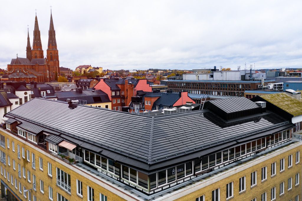 Gul fasad med svart tak med solpaneler